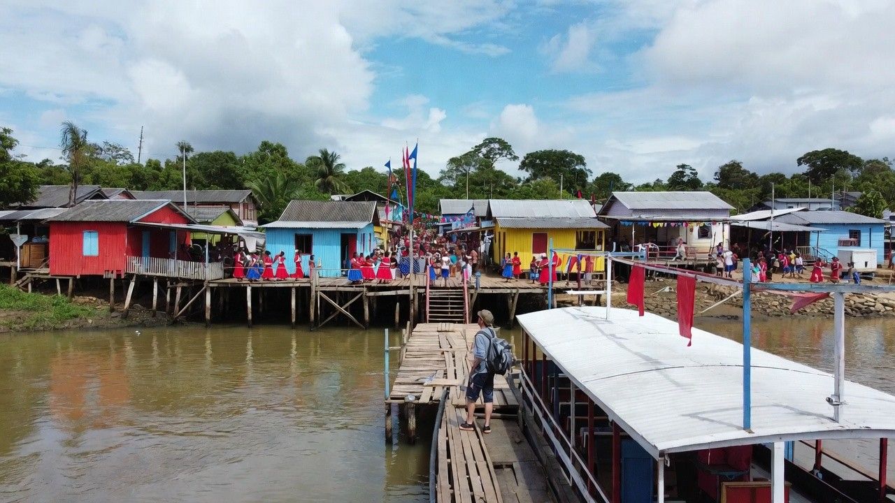 Traveler arriving by riverboat at Parintins town decorated for the Parintins Folklore Festival 2026 in the Amazon