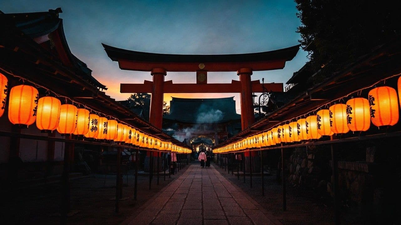 Yasaka Shrine torii gate with glowing orange lanterns at dusk Gion Matsuri Kyoto