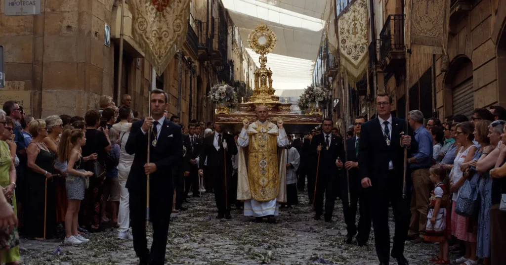 Corpus Christi Festival 2026 procession through narrow cobblestone streets in Toledo Spain with gold monstrance being carried by clergy