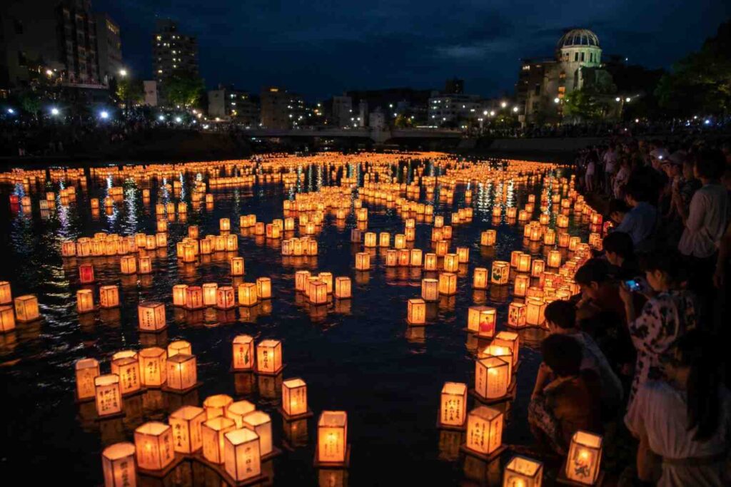 Floating paper lanterns on a river during Japan's Obon festival at night