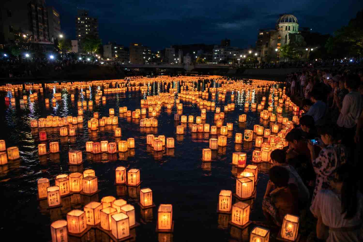 Floating paper lanterns on a river during Japan's Obon festival at night