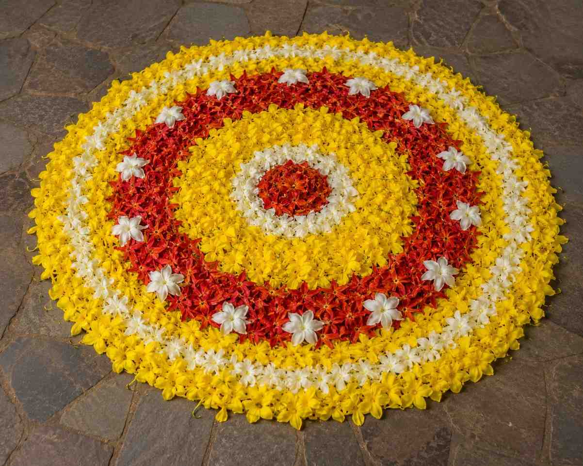 Traditional onam pookalam made with konna, chethi and thumba flowers arranged in concentric circles