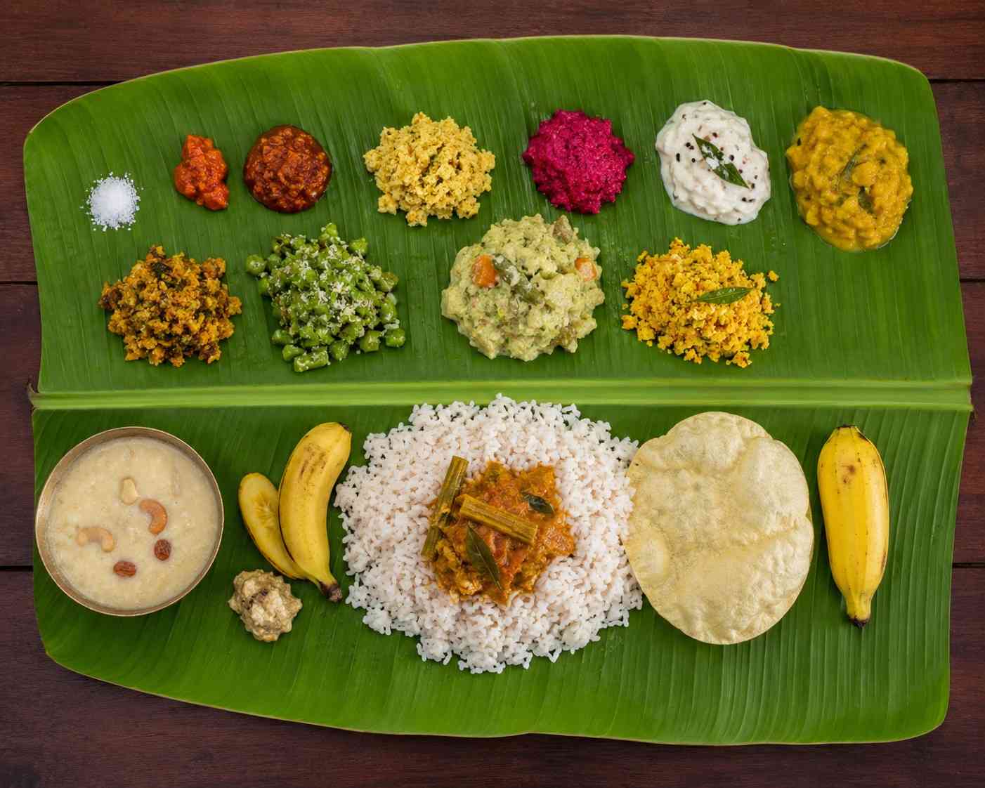 Traditional onam sadya served on banana leaf with rice, sambar, avial, payasam and pappadam