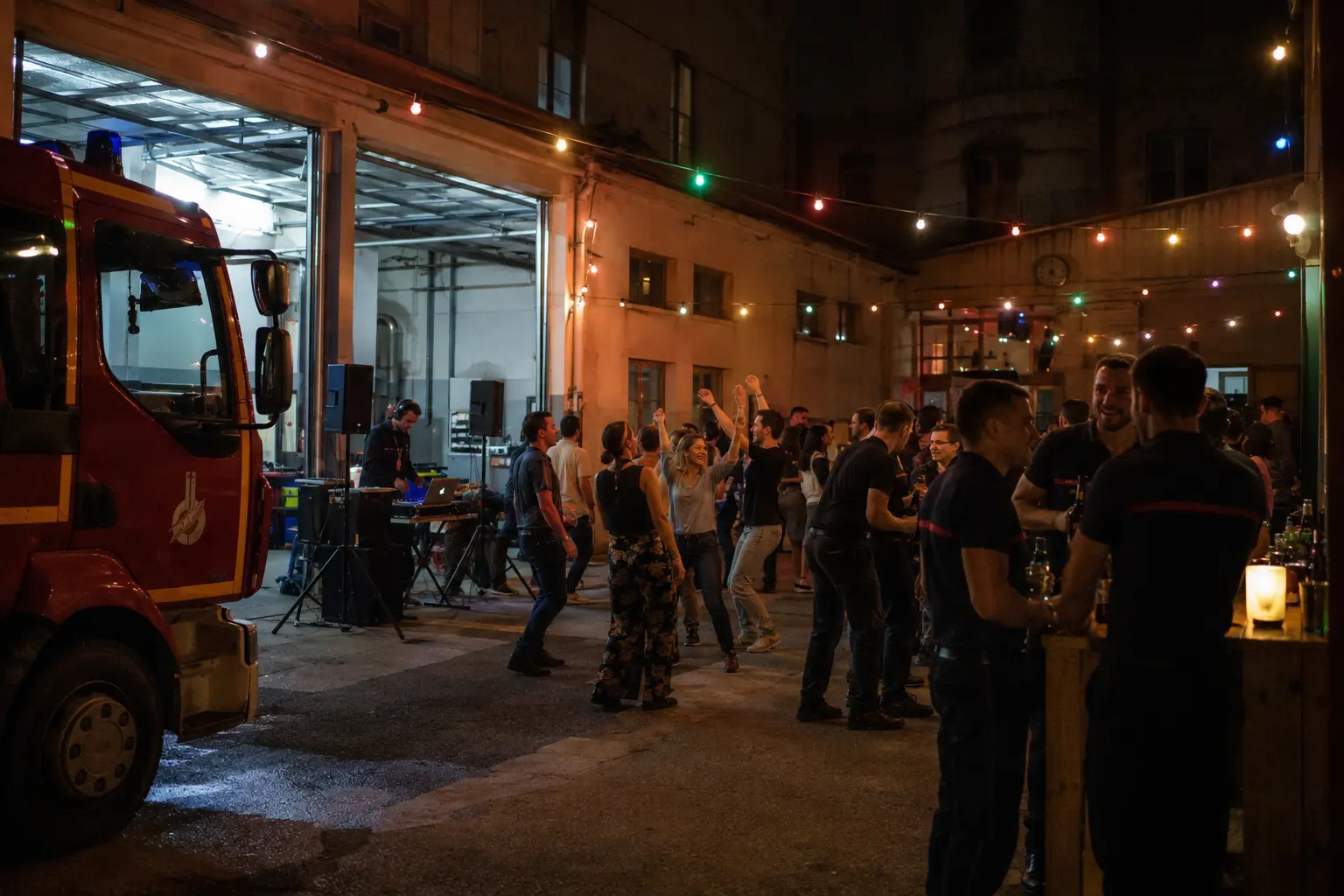 Bal des pompiers firefighters ball celebration crowd dancing in a French fire station courtyard