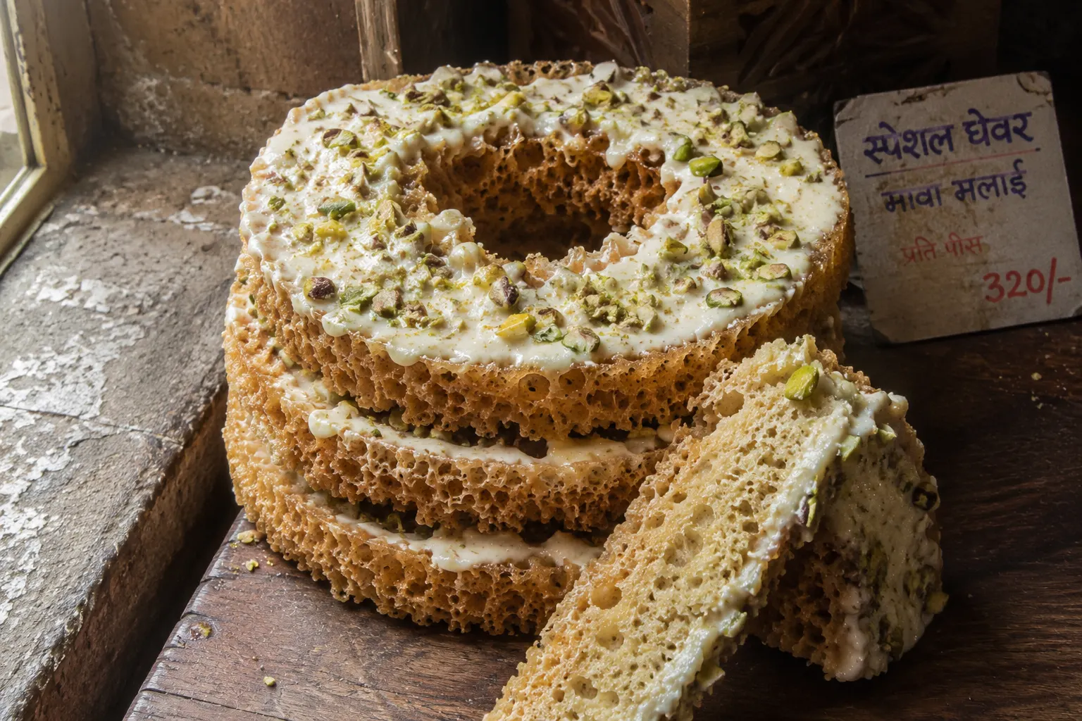 Ghevar — traditional Rajasthani sweet eaten during Teej festival, topped with rabdi and pistachios