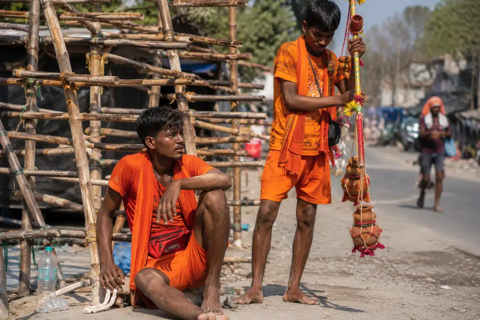 Kanwariya holding a Khadi Kanwar upright during Kanwar Yatra 2026 so it never touches the ground