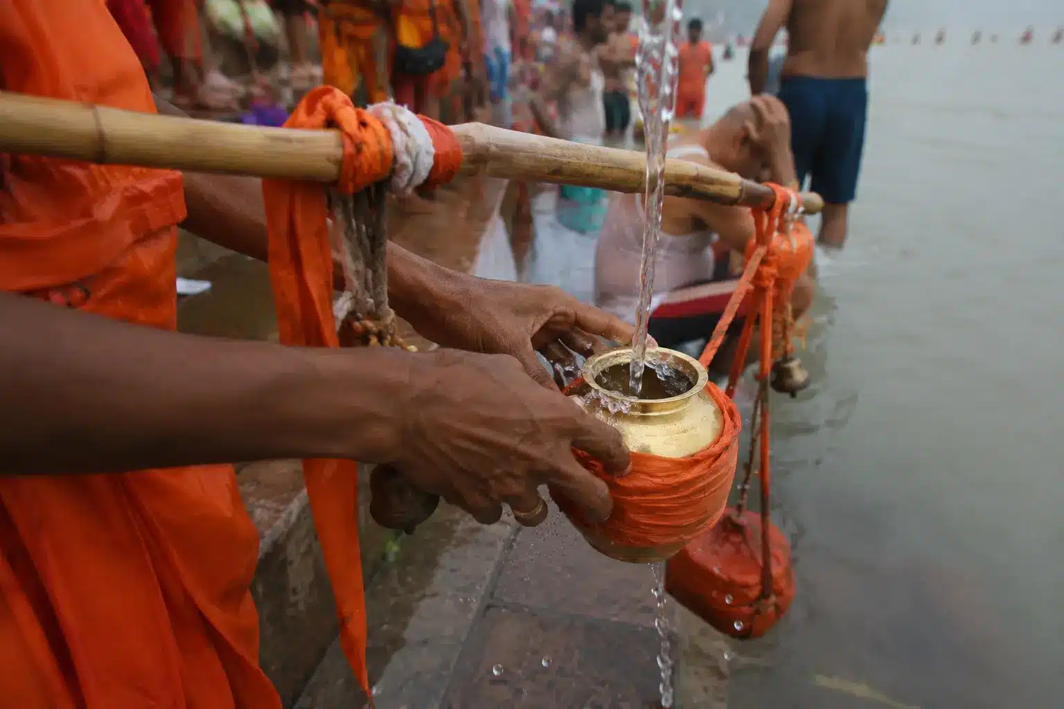 Kanwar Yatra 2026 devotee filling pot with Ganga water at Haridwar ghat for Jalabhishek