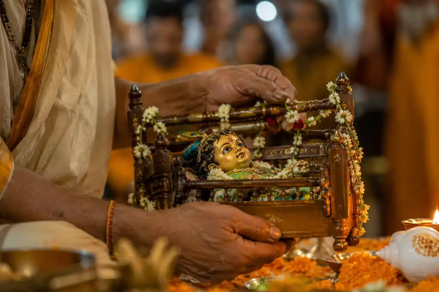 Janmashtami 2026 midnight puja — priest rocking infant Krishna's cradle during Nishita Kaal ritual