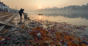 Wilted festival flower waste floating along an Indian river ghat the morning after immersion