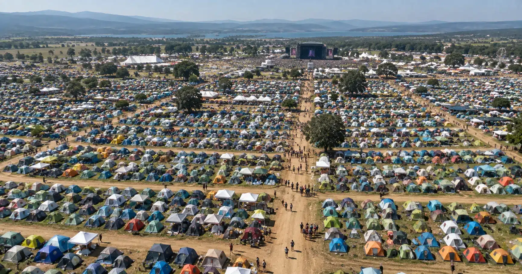 An aerial view of a massive festival campsite with thousands of tents