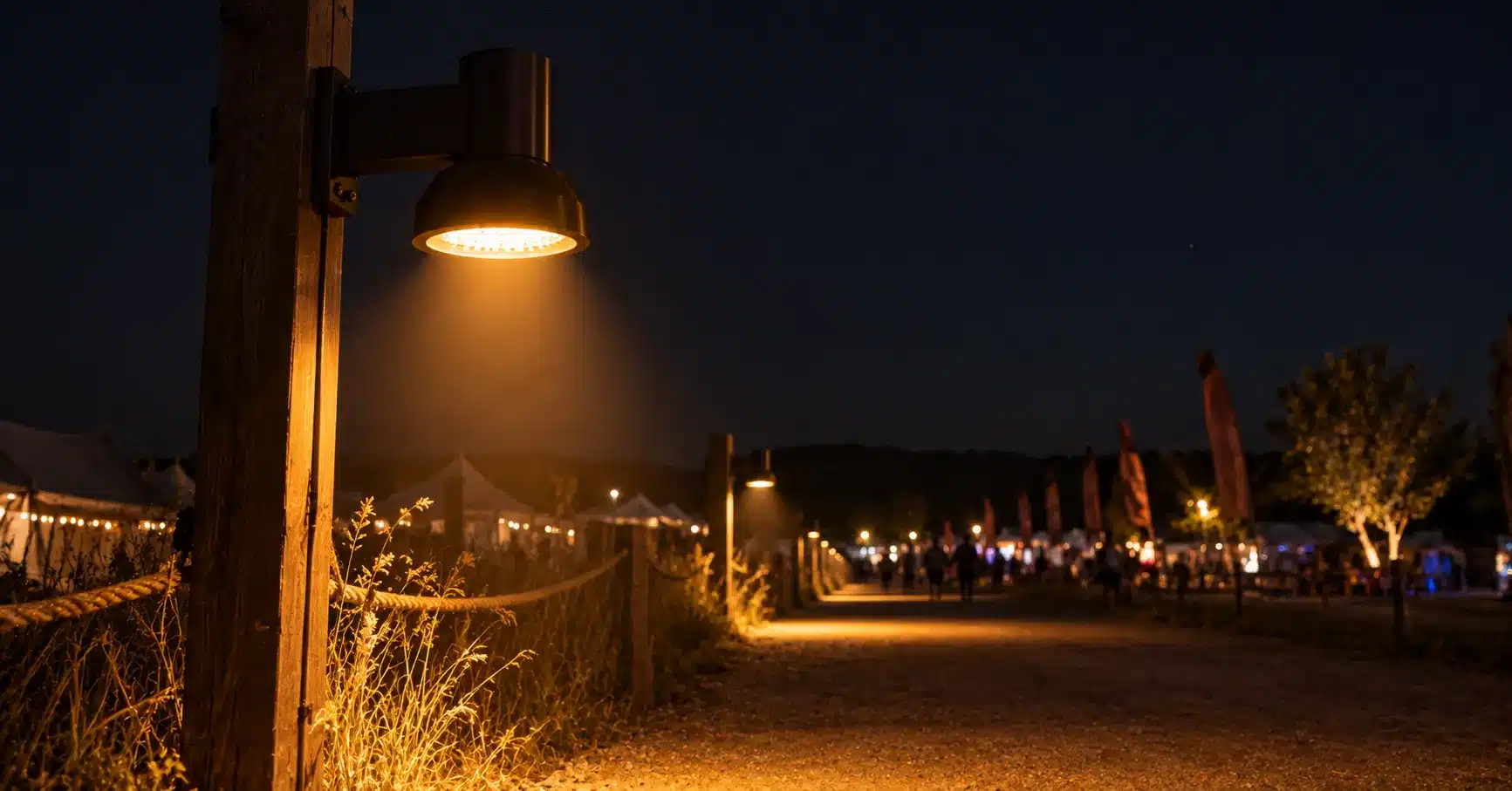 A shielded, warm-toned outdoor light fixture directing light downward with no upward spill