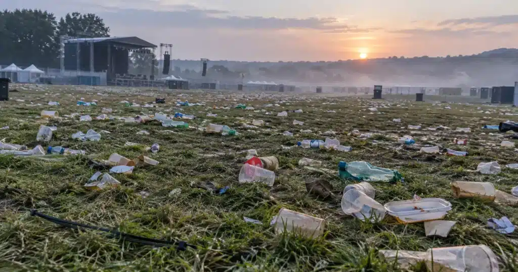 festival plastic : Plastic cups and bottles scattered across an empty festival field at dawn