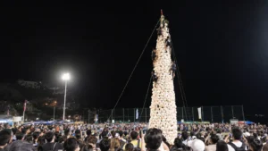 Climbers racing up a tower of white buns under floodlights at the Cheung Chau Bun Festival final